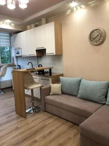 a living room with a couch and a kitchen at Goldenhaus Pushkina str.27 in Vinnytsya