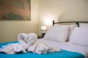 a bed with a pile of towels on it at Delphinus Villa Nefeli in Agios Nikitas