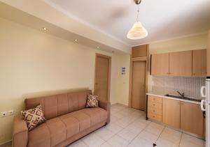 a living room with a brown couch in a kitchen at Delphinus Villa Nefeli in Agios Nikitas