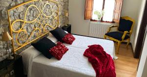 HinojedoにあるLa Casa de Noeliaのベッドルーム(白いベッド、赤い枕付)