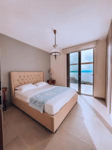 - une chambre avec un grand lit et une vue sur l'océan dans l'établissement Stone built house next to the beach, à Amoliani