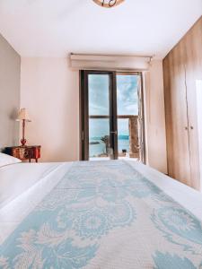- une chambre avec un lit et une vue sur l'océan dans l'établissement Stone built house next to the beach, à Amoliani