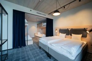 a bedroom with a large bed and a mirror at Comfort Hotel Solna Arenastaden in Solna