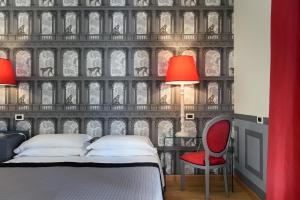 una camera con letto, lampade rosse e parete di Adua & Regina di Saba Wellness & Beauty a Montecatini Terme