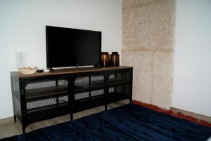 a television on a black stand in a room at Imperial Douro Apartamento 3 in Peso da Régua