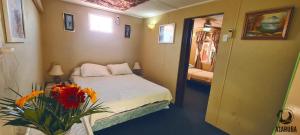 um pequeno quarto com uma cama e um vaso de flores em A1 Apartments Aruba em Oranjestad