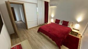 a bedroom with a red bed and a mirror at Oriana in Constanţa