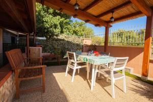 a patio with a table and chairs under a pergola at Arcobaleno 2 in Villasimius