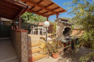 a patio with an outdoor oven and a table and chairs at Arcobaleno 2 in Villasimius