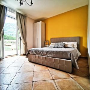 ein Schlafzimmer mit einem großen Bett und einer gelben Wand in der Unterkunft Il Sentiero di Leano in Terracina