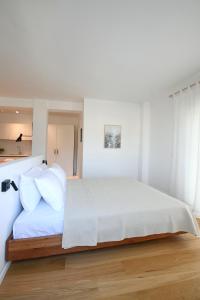 a bedroom with a large white bed with white pillows at m2studio in Kavála