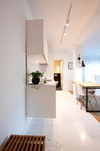 a kitchen and dining room with white walls and a table at m2studio in Kavála