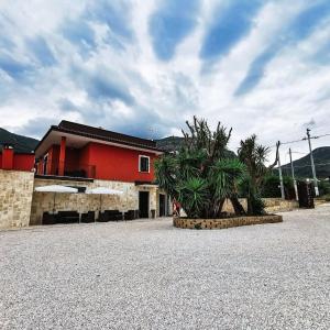 un edificio rojo con una palmera delante en Il Sentiero di Leano en Terracina