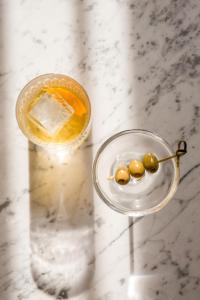 a glass of drink with olives on a table at The Pilgrm in London
