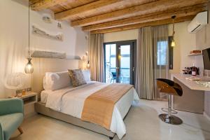 a bedroom with a bed and a table with a chair at Mitos-Suites in Rethymno Town