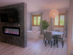 a living room with a fireplace and a dining room table at La Bohème - Bed & Breakfast in Bromont