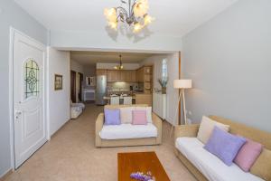 a living room with two couches and a kitchen at Nicoles Houses Arillas Corfu in Arillas