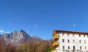 a white building with a mountain in the background at Antico Melo B&B in Vignole