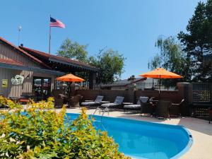 a swimming pool with chairs and umbrellas next to a building at Coachman Inn Oak Harbor in Oak Harbor