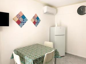una sala da pranzo con tavolo e frigorifero di RockSea Apartments a Cefalù