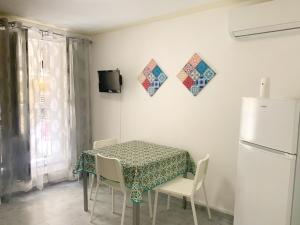 una cucina con tavolo, sedie e frigorifero di RockSea Apartments a Cefalù