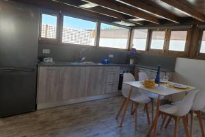 cocina con mesa, sillas y fregadero en Apartamento Eucalipto, en Mozaga