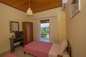 a bedroom with a bed and a window with a view at Nicoles Houses Arillas Corfu in Arillas