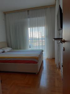 sypialnia z łóżkiem i dużym oknem w obiekcie Apartment Nana w Barze