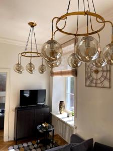 a living room with three lights hanging from the ceiling at Liepaja Center Theater Apartments in Liepāja