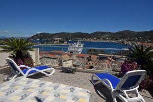 a patio with a table and chairs and a boat in the water at Apartment II Radisic beautiful view in Vis