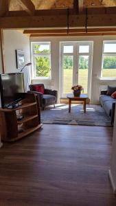 a living room with a tv and a couch at Ferienwohnung Wald und Weitblick in Dreschvitz