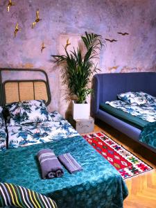 a bedroom with a blue bed and a plant at Pokoje przy plaży z widokiem na morze in Sopot