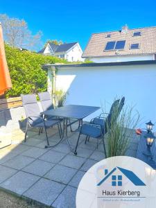 een patio met een tafel en stoelen naast een zwembad bij Haus Kierberg in Monschau