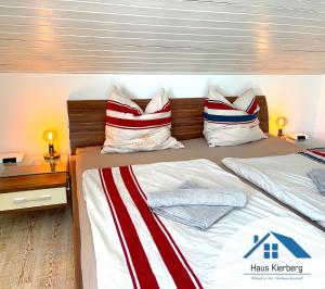 een slaapkamer met een bed met rode witte en blauwe kussens bij Haus Kierberg in Monschau