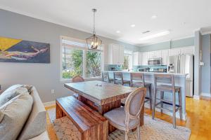 a living room with a wooden table and a kitchen at Cool Corner in Folly Beach