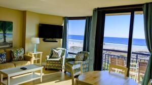 a living room filled with furniture and a view of the ocean at Shell Island Resort - All Oceanfront Suites in Wrightsville Beach