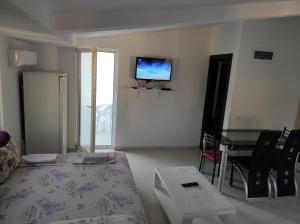 Zimmer mit einem Bett, einem Tisch und einem TV in der Unterkunft Apartment Perutović in Sutomore