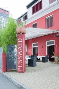 un poste rojo con una planta delante de un edificio en Hotel Restaurant Pusswald en Hartberg