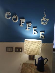 ein Tisch mit einer Lampe und einem Schild an einer Wand in der Unterkunft Le Lamie in Sessa Cilento