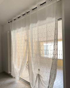 una finestra con tende bianche in una stanza di U Carùggiu a Villanova dʼAlbenga
