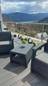 a patio with a table and chairs on a deck at Mountain and Lake Views beautiful Miedzybrodzie in Międzybrodzie Bialskie