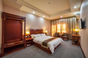 a hotel room with a bed and a table and chairs at Hotel Shanghai City in Osh