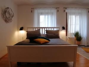 a bed in a room with two windows at Ferienwohnung Familie Rauch in Feldkirchen in Kärnten