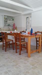a kitchen with a wooden table and chairs at Afales View in Vathi