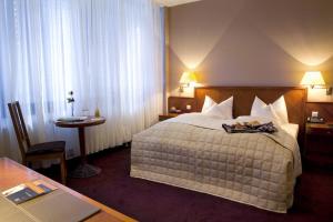 a hotel room with a bed with a tray on it at ROSS Hotel in Stuttgart