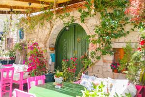 a green door in a building with tables and chairs at Apaz Alaçatı Hotel in Alacati