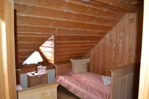 a small room with a bed in a wooden house at Pension Lucia Bucovina in Vama