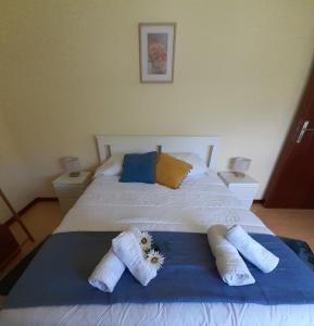 Un dormitorio con una cama blanca con toallas. en Apartment Sweet Home, en Ponta Delgada