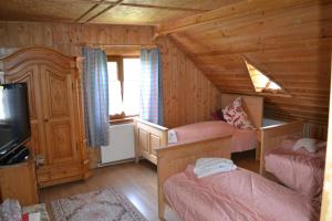 a bedroom with two beds and a tv in a cabin at Pension Lucia Bucovina in Vama