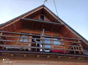 コシチェリスコにあるPokoje u Sarnowskichの木造の家屋で、バルコニーが付いています。